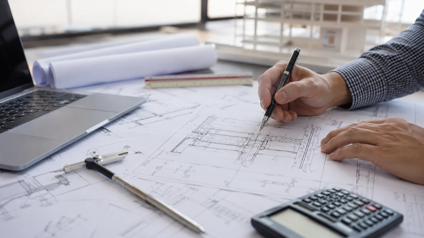 Engineering drawings reviewed on a desk